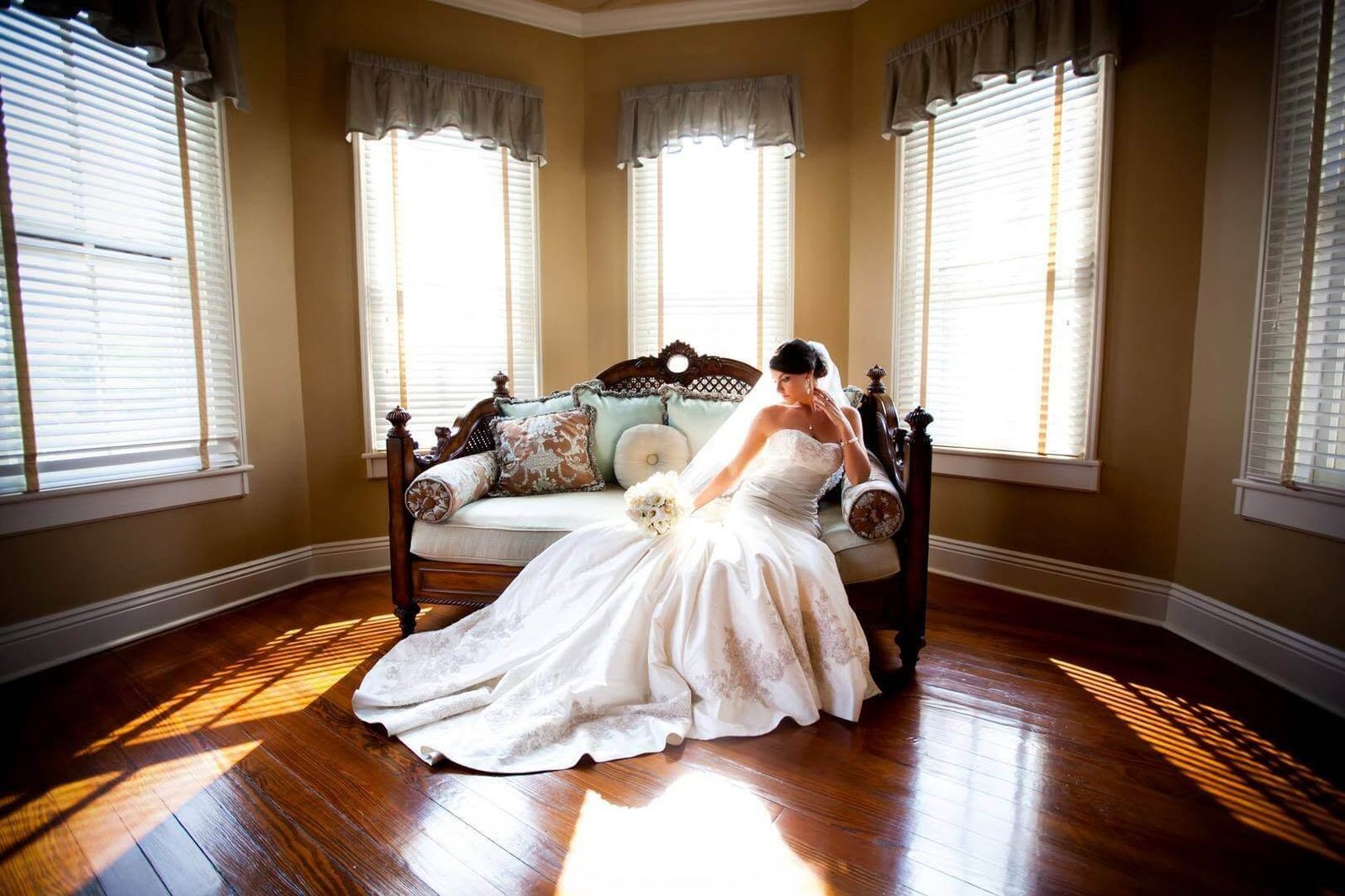 The bridal suite at The Caldwell House — antique settee in the bay-window light